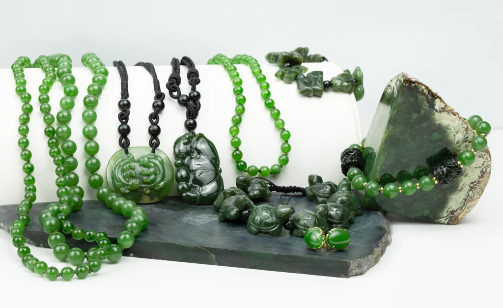 Assorted nephrite jade necklaces, bracelets, and carved pendants in various shades of spinach green.