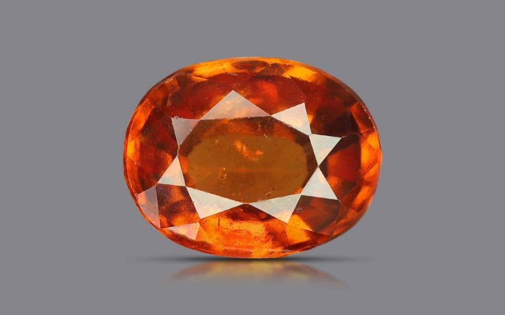 第二の画像の標本は、深い赤みがかったオレンジ色からシナモンブラウンの色調を示しており、ヘソナイトの色相スペクトルにおいてより飽和度が高く、高価とされる領域に位置します。この鮮やかな発色は高品質なカルシウムアルミニウムケイ酸塩ガーネットの特徴であり、暖色系の照明下では豊かで輝く炭火のように見えることがよくあります。