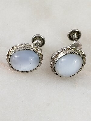 Pair of vintage milk glass cabochon earrings set in decorative metal frames, featuring the signature opaque, milky-white appearance characteristic of historic milk glass jewelry.