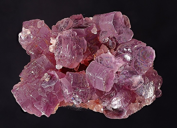 具有特征性单斜棱柱形状和鲜艳品红至紫罗兰色调的晶体状锂云母集合体,突显了其完美的底面解理。