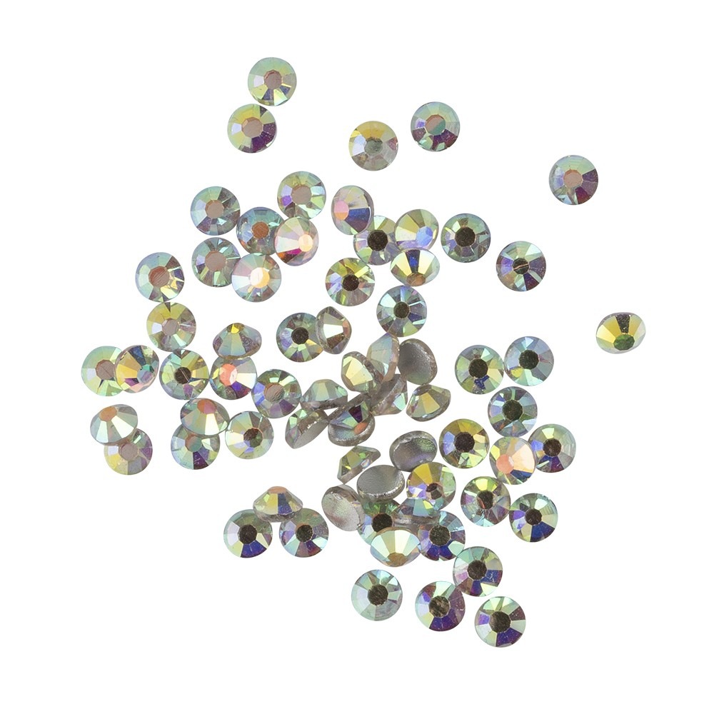 A scattered collection of small, faceted clear Strass glass stones, each exhibiting an iridescent, multi-colored shimmer across their surfaces.