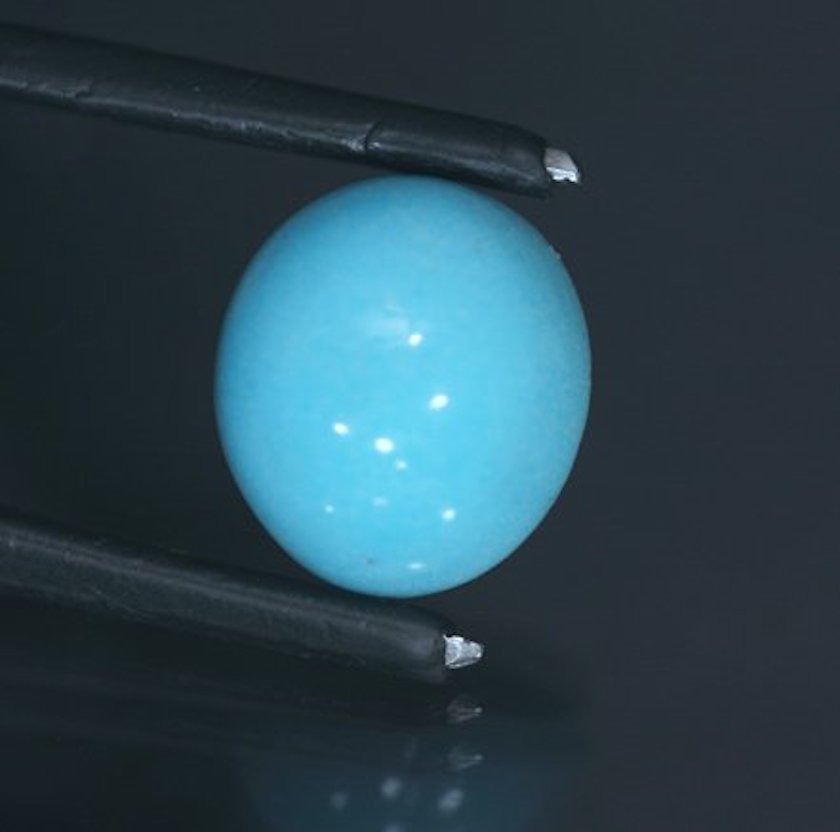 Vivid sky blue Prosopite cabochon showcasing its resemblance to turquoise and its characteristic waxy to vitreous luster.