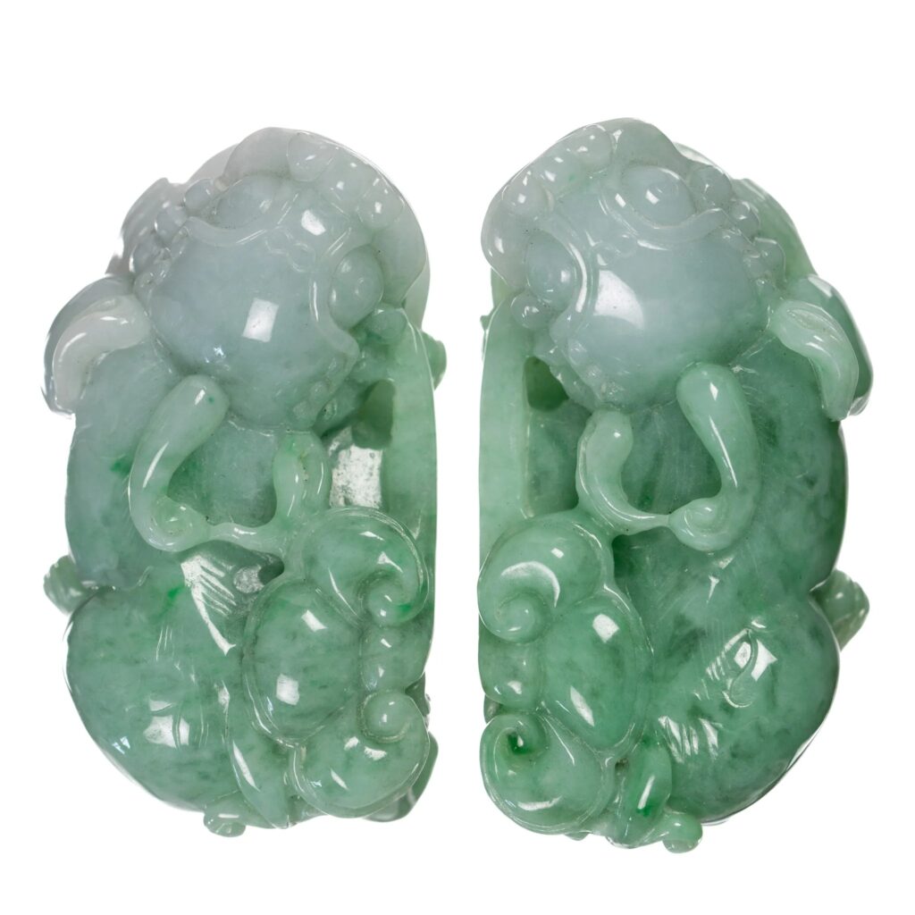 Hand-carved jadeite pendants representing the Chinese mythical creature Pixiu, showcasing traditional craftsmanship and semi-translucent green gemstone quality.