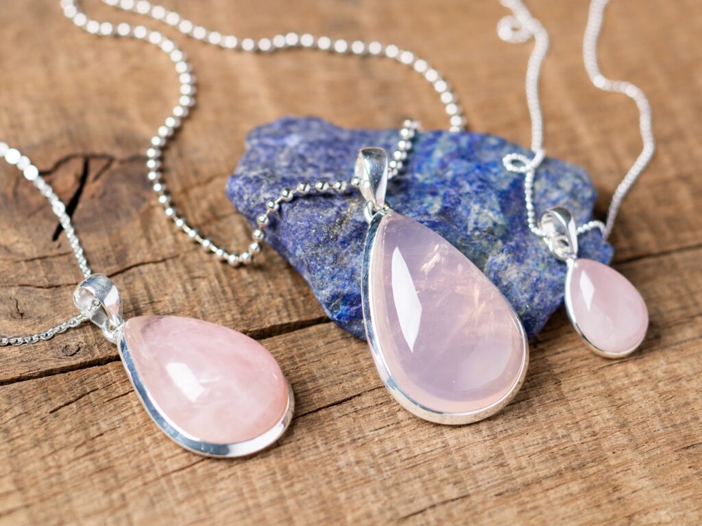 配有银色金属镶嵌的水滴形粉晶吊坠。