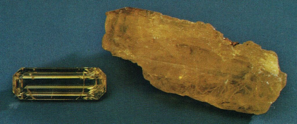 Rare faceted legrandite gemstone displaying high transparency next to a raw canary yellow legrandite mineral fragment.