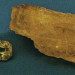 Seltener facettierter Legrandit-Edelstein mit hoher Transparenz neben einem rohen, kanariengelben Legrandit-Mineralfragment.