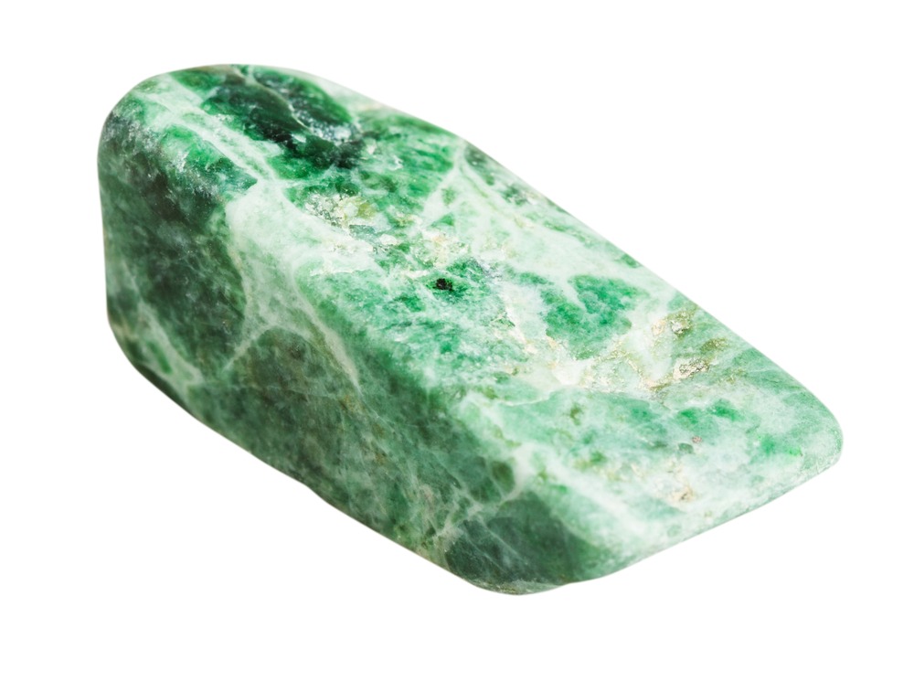 Polished specimen of jadeite jade showing characteristic granular structure and varying shades of green due to chromium and iron content.