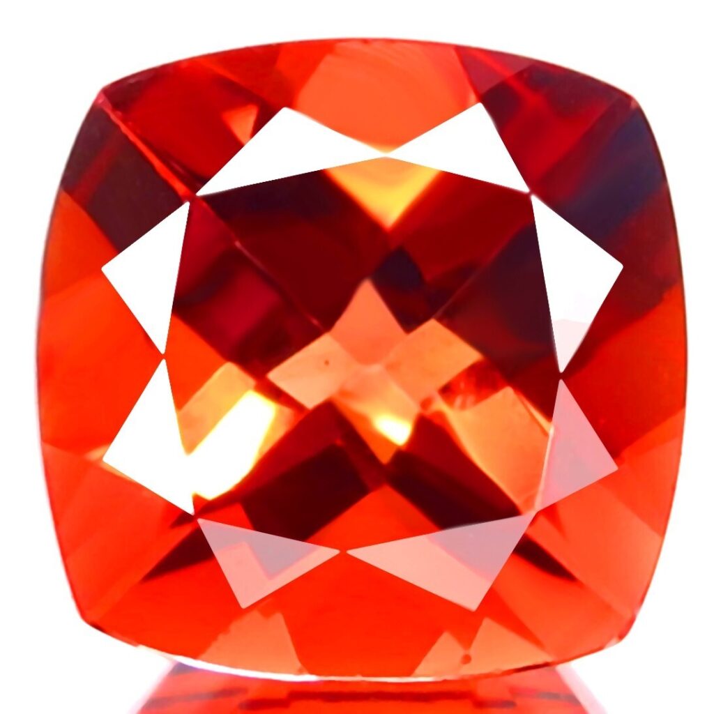 날카로운 패싯과 유리 광택이 특징인 화려한 쿠션 컷 주황색 안데신 보석의 근접 촬영 사진.