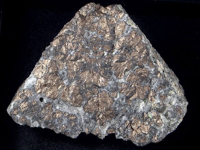 Especimen mineral de nicolita masiva con brillo metálico rojo cobre.