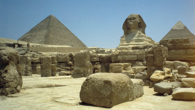 埃及晴朗蓝天下的吉萨大狮身人面像与吉萨金字塔群。