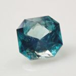 Ein im Smaragd- oder Octagonschliff facettiertes Grandidierit-Mineralexemplar, das den charakteristischen blau-grünen Pleochroismus und hohe Transparenz aufweist.