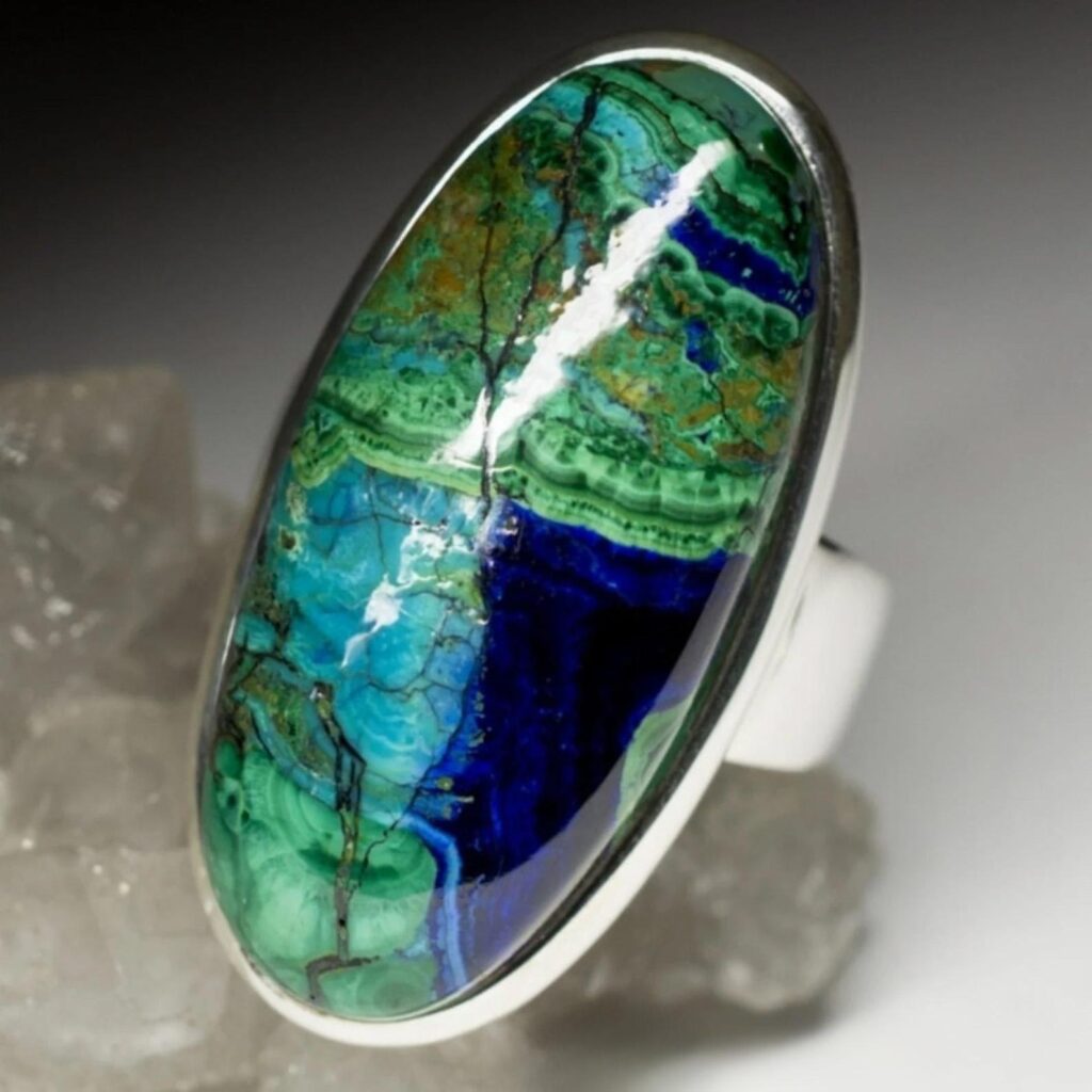 A silver ring featuring a polished oval azurmalachite gemstone.
