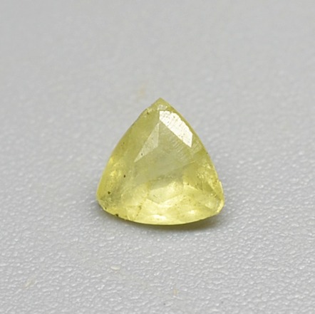 Permata shortite berwarna kuning muda dengan potongan segitiga dan berfaset, dengan berat 0,18 karat.