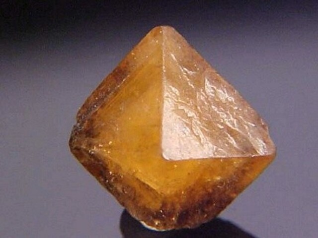 Mellite, Artern, Distrik Kyffhäuser, Thuringia, Jerman. Kristal tunggal Mellite yang tajam, berkilau, transparan hingga hampir menyerupai permata, berukuran 1 cm x 0,8 cm x 0,6 cm. Ini adalah contoh luar biasa dari spesies organik yang sangat jarang ditemui ini, dari lokalitas tipe.