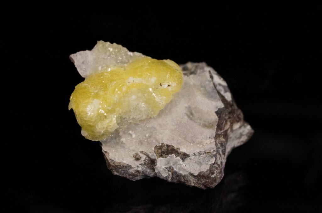 Bright yellow botryoidal brucite crystal aggregate on rock matrix