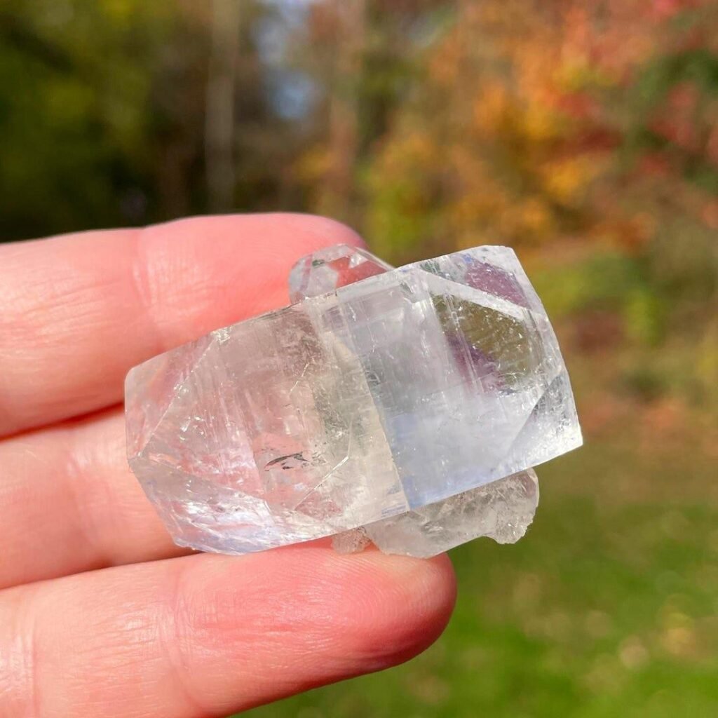 Close-up of a transparent apophyllite crystal showing its vitreous luster and flat cleavage surfaces.